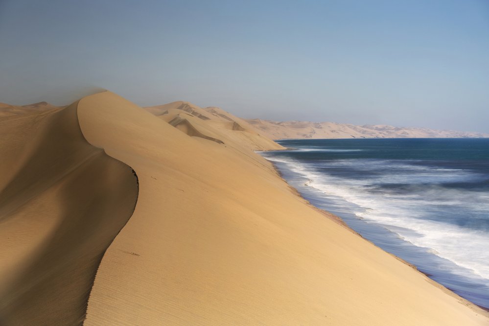Namib Naukluft National Park, Namibie: Národní park Namib Naukluft najdeme na západě Namibie. Součástí parku je podstatný kus Namibské pouště, nejstarší pouště světa, jižní konec pohoří Naukluft a také laguna v zátoce Sandwich na pobřeží Atlantiku. Výsledkem této kombinace jsou vskutku jedinečné spektákly. Rozsáhlé písečné duny Namibské pouště padají až do samotného oceánu a nějakou tu zeleň najdete až v horách na východním konci parku. Nejpozoruhodnější částí parku je pak jílová a solná pánev Sossusvlei obklopená vysokými rudými dunami.