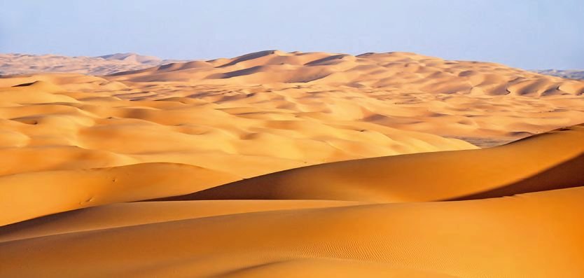 Písečné duny obklopující hory v jižním Alžírsku.