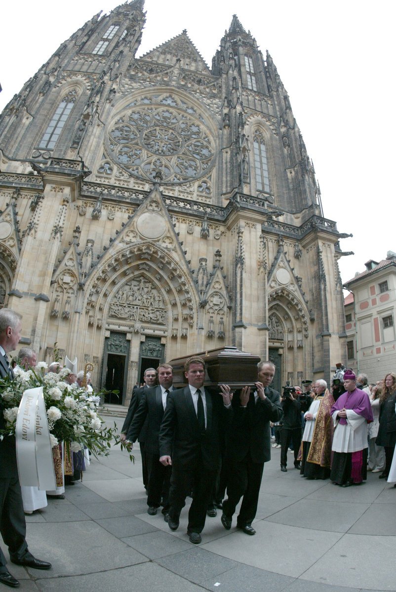 Šestice mužů nese rakev z chrámu Sv. Víta do pohřebního vozu. 