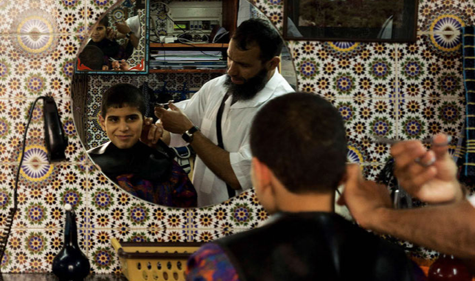 Chlapec u holiče v Rabatu, Maroko.