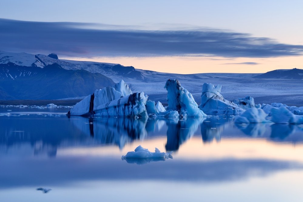 Ledovcová laguna Jökulsárlón. Laguna má plochu zhruba 18 kilometrů čtverečních a nalézá se mezi mořem a ledovcem Breiðamerkurjökull. Z něj se odtrhávají ledové kry, které pak volně plují po hladině laguny. Dopravu turistů po jezeře obstarávají obojživelné čluny.