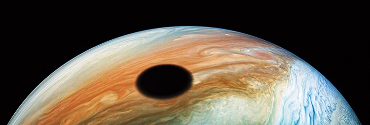Stín, který na Jupiter vrhá měsíc Io na snímku ze sondy Juno