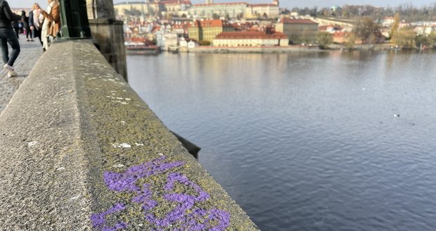 Karlův most se stal znovu terčem vandalů. Tentokrát se na něm objevil fialový nápis. (10. listopad 2021)