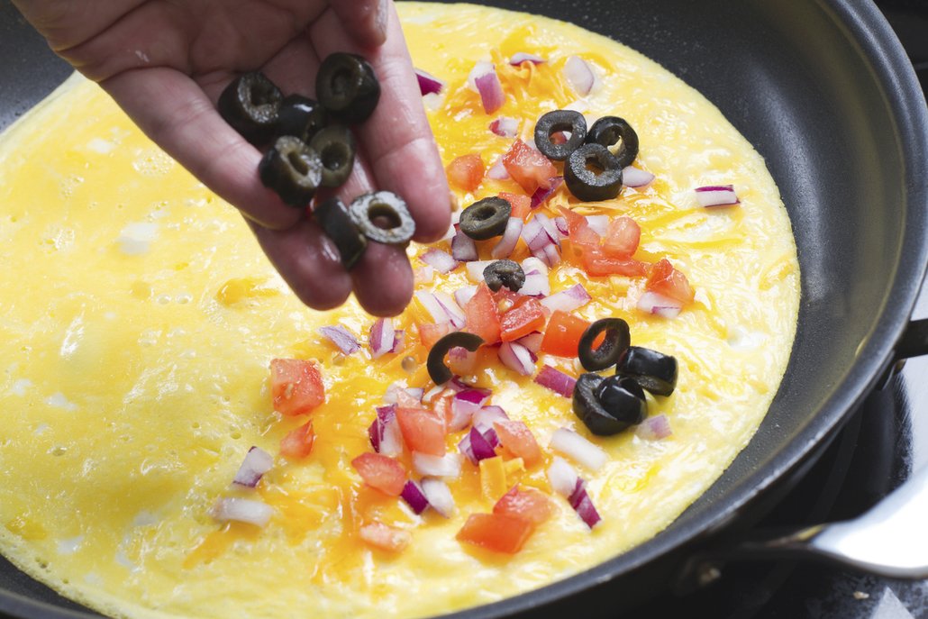 Pokud se vám klasická verze omelety omrzí, můžete klidně do vajíček zamíchat nasekané čerstvé bylinky, šunku, cibulku, zeleninu, olivy, zkrátka vše, co vám chutná
