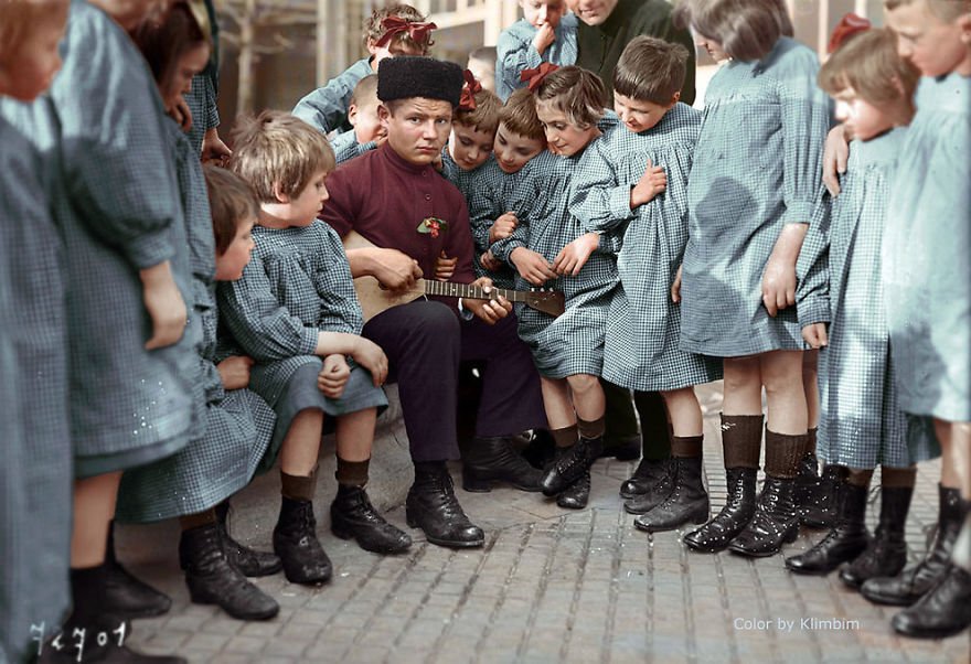 Mladý muž hraje ruským dětem, rok 1940.