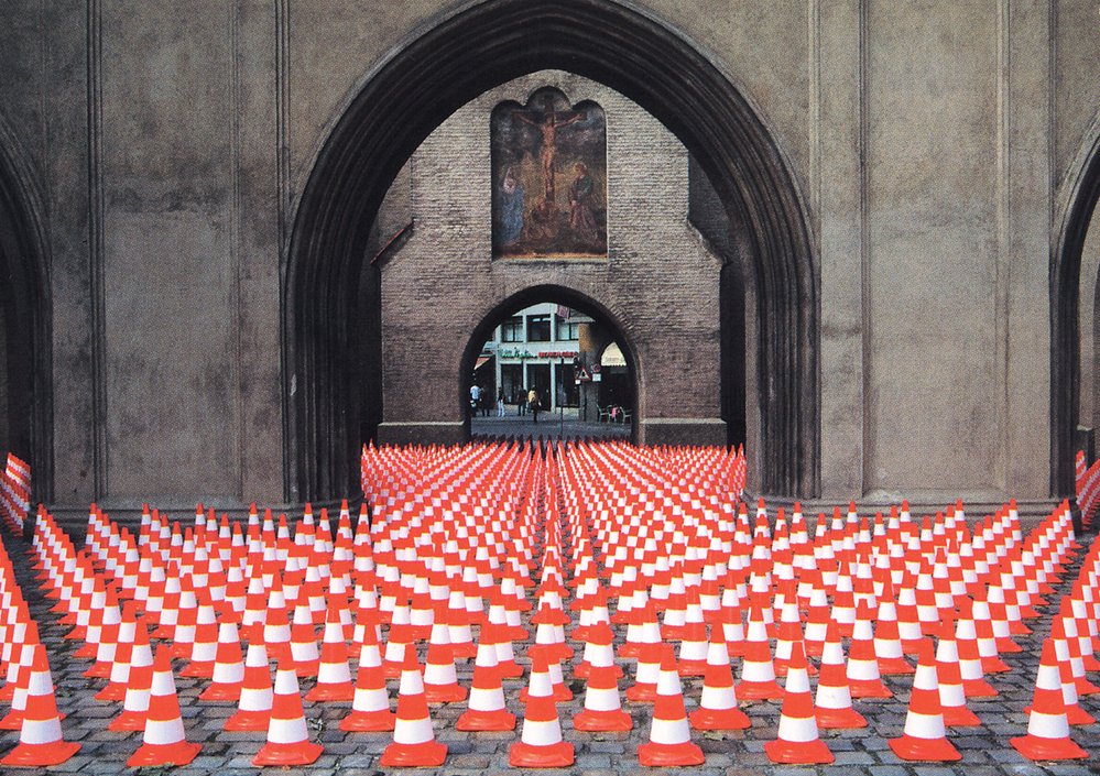 Výstraha z radosti (1992/1997). Asi 2000 výstražných jehlanců, výška 50 cm, plocha 816 m2, Isartorplatz, Mnichov (Německo)