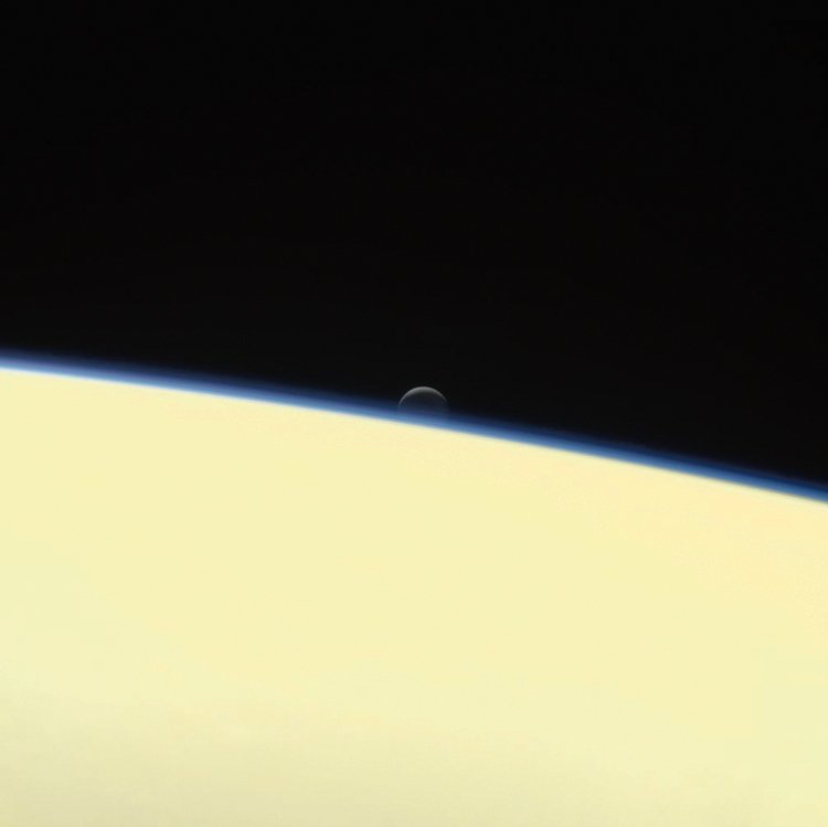 Jedna z posledních fotek zachycuje Saturn a nad ním měsíc Enceladus