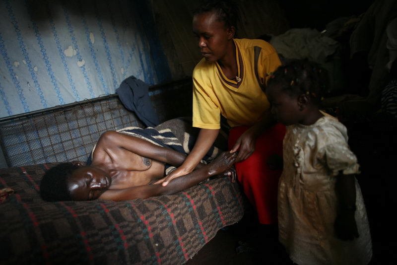 Slum Kibera, Nairobi, Keňa 2007. Timina Mungoeová, třicet let. Je HIV pozitivní, zároveň má rakovinu jater. Umírá.