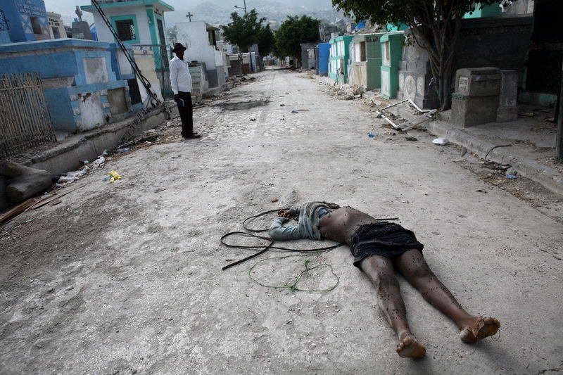 Port-au-Prince, Haiti 2010. Před vchodem na hřbitov v Port-au-Prince. Ještě deset dní po zemětřesení ležela po městě neodklizená těla obětí.
