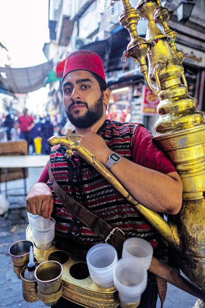 Cinkající muži rozlévají v blízkovýchodních městech vodu nebo tamarindový džus