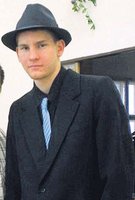Na osudném plese měl Tomáš černý klobouk a černý oblek s kravatou. 