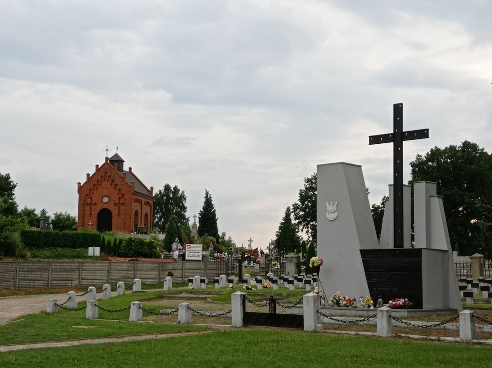 Pomník padlým polským vojákům z roku 1939 v Milejowě s hřbitovní kaplí v pozadí